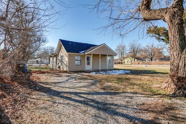 view of property exterior featuring fence and roof with shingles