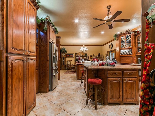 8501 S Council Rd, Oklahoma City, OK 73169 - kitchen with stainless steel fridge, ceiling fan, ornamental molding, a chandelier, and a breakfast bar area
