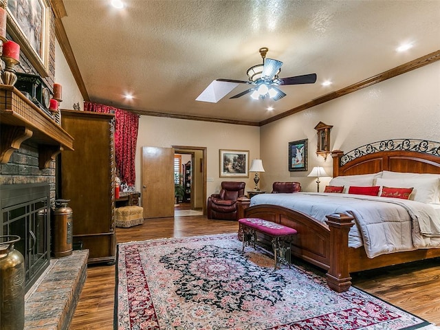 8501 S Council Rd, Oklahoma City, OK 73169 - bedroom featuring a textured ceiling, crown molding, wood finished floors, a ceiling fan, and a fireplace