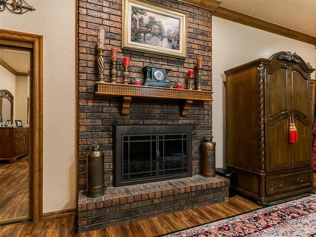 8501 S Council Rd, Oklahoma City, OK 73169 - detailed view of wood finished floors, crown molding, a brick fireplace, a textured wall, and baseboards