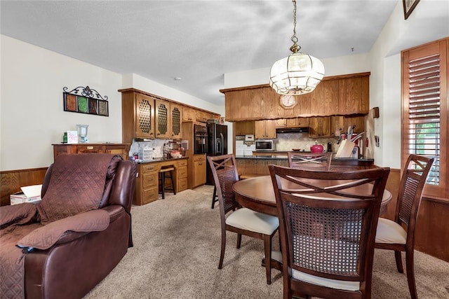 7108 S Kentucky St, Oklahoma City, OK 73159 - dining space with light carpet, a chandelier, and a wainscoted wall