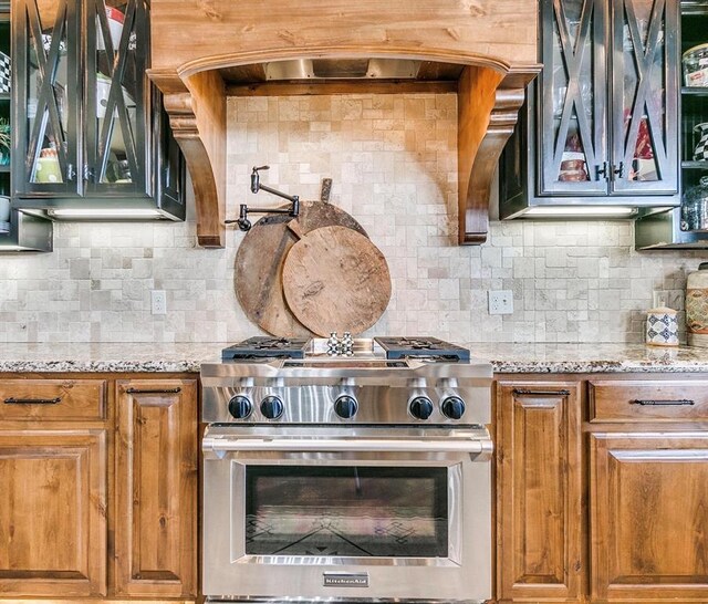 5400 N Piedmont Rd Unit A, Piedmont, OK 73078 - kitchen featuring high end stainless steel range oven, light stone counters, backsplash, and brown cabinets
