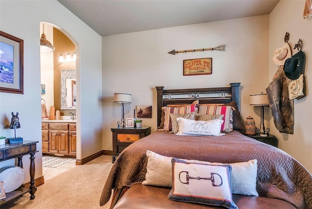 5400 N Piedmont Rd Unit A, Piedmont, OK 73078 - bedroom featuring arched walkways, ensuite bathroom, and light colored carpet