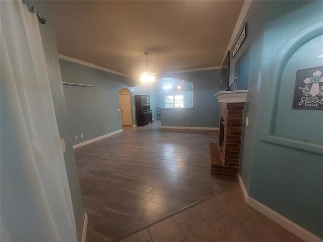 531 W Shadow Ridge Way, Mustang, OK 73064 - unfurnished living room with ornamental molding, arched walkways, a fireplace, baseboards, and wood finished floors