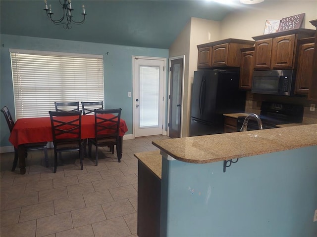 531 W Shadow Ridge Way, Mustang, OK 73064 - kitchen with black appliances, light countertops, vaulted ceiling, a chandelier, and a kitchen bar