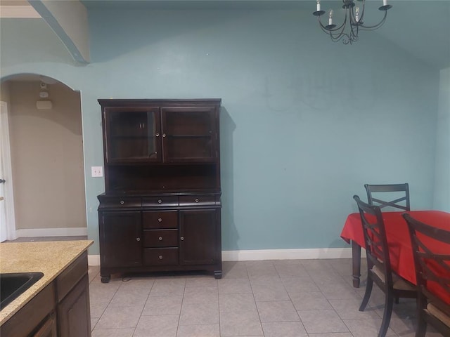 531 W Shadow Ridge Way, Mustang, OK 73064 - dining area with arched walkways, a chandelier, light tile patterned floors, and baseboards