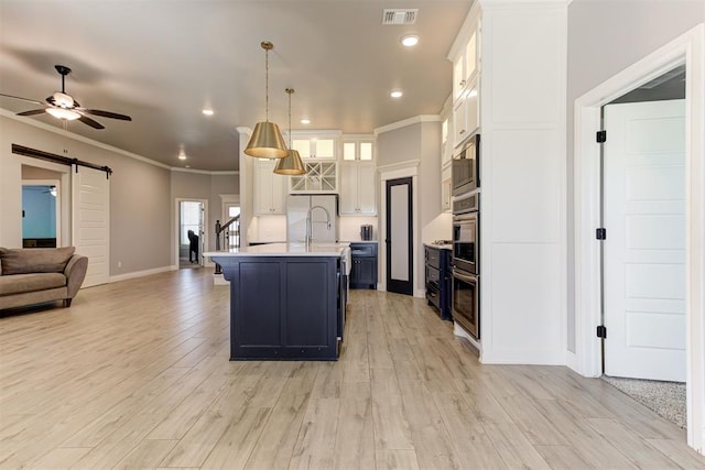 3024 Drake Crest Dr, Edmond, OK 73034 - kitchen with open floor plan, a barn door, light countertops, ceiling fan, and baseboards
