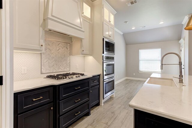 3024 Drake Crest Dr, Edmond, OK 73034 - kitchen with a sink, stainless steel appliances, dark cabinetry, white cabinets, and baseboards