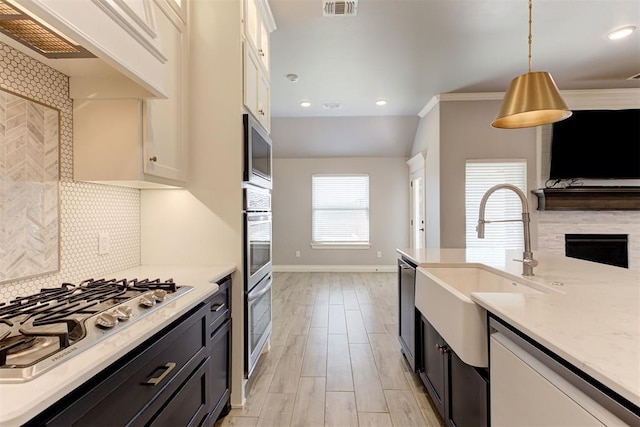 3024 Drake Crest Dr, Edmond, OK 73034 - kitchen with appliances with stainless steel finishes, white cabinetry, a sink, decorative backsplash, and baseboards