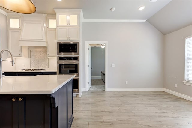 3024 Drake Crest Dr, Edmond, OK 73034 - kitchen featuring appliances with stainless steel finishes, light countertops, white cabinetry, tasteful backsplash, and light wood-type flooring