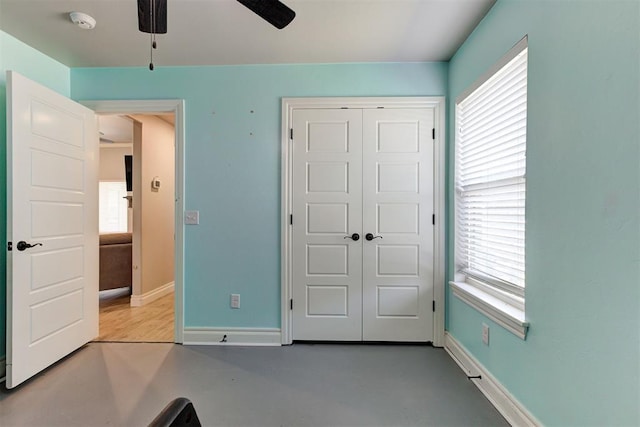 3024 Drake Crest Dr, Edmond, OK 73034 - unfurnished bedroom with a closet, baseboards, ceiling fan, and finished concrete flooring