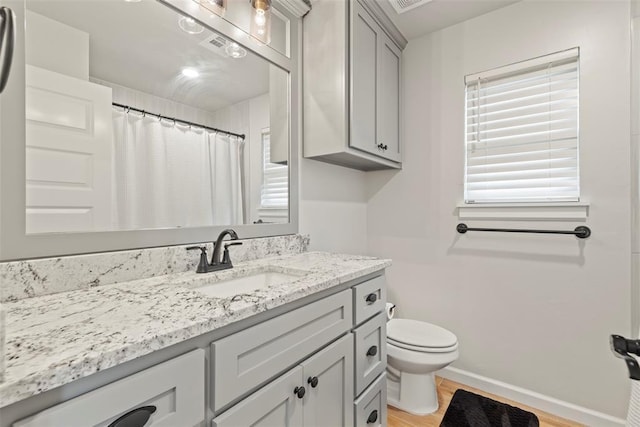 4705 Bermuda Dr, Mustang, OK 73064 - full bathroom with toilet, vanity, wood finished floors, baseboards, and a shower with shower curtain