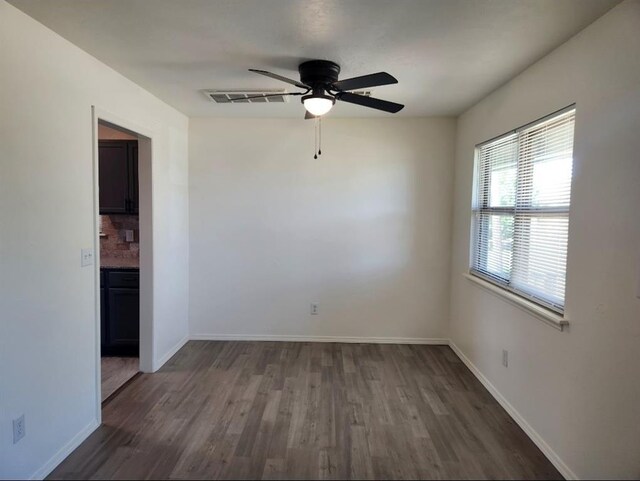 2421 N Prospect Ave, Oklahoma City, OK 73111 - unfurnished room featuring dark wood-type flooring, a ceiling fan, and baseboards