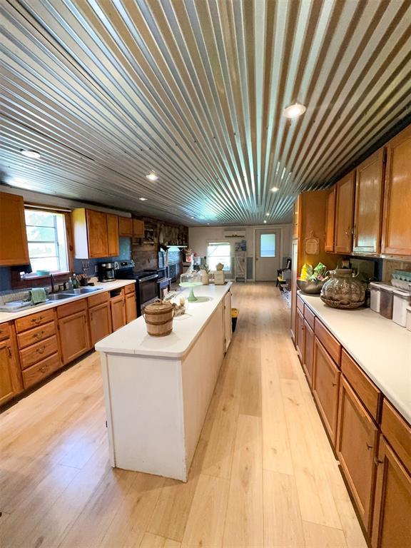 218 N 4150th Rd, Antlers, OK 74523 - kitchen featuring black / electric stove, light countertops, brown cabinetry, a kitchen island, and recessed lighting