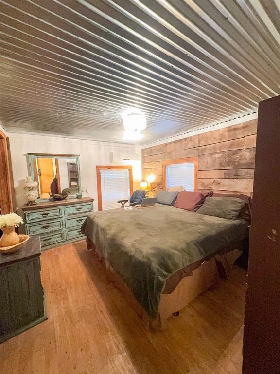 218 N 4150th Rd, Antlers, OK 74523 - bedroom with wood finished floors and wooden walls