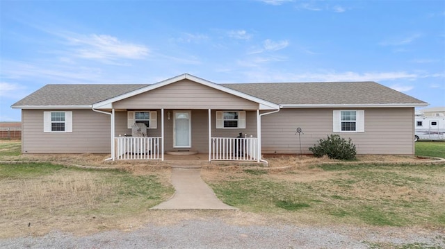 22950 E 1130th Rd, Bessie, OK 73622 - single story home with a porch, a front lawn, and a shingled roof