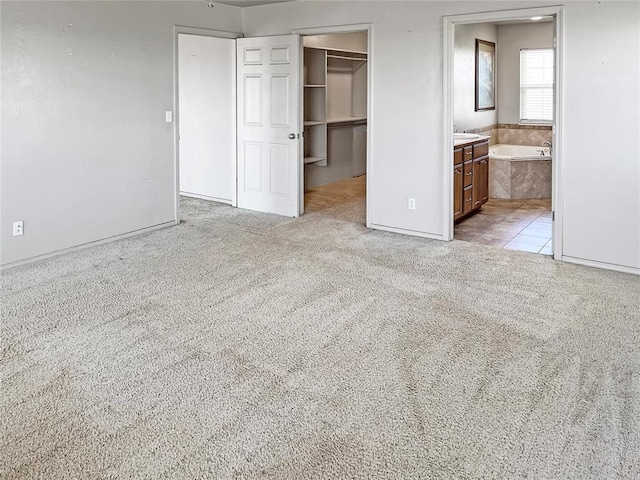 22950 E 1130th Rd, Bessie, OK 73622 - unfurnished bedroom with a walk in closet, a closet, and light colored carpet