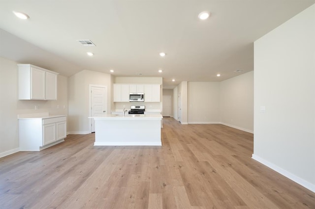10324 NW 28th St, Yukon, OK 73099 - kitchen featuring appliances with stainless steel finishes, baseboards, white cabinets, recessed lighting, and a center island with sink