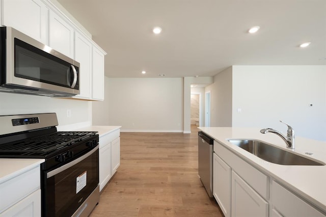 10324 NW 28th St, Yukon, OK 73099 - kitchen featuring appliances with stainless steel finishes, a sink, light wood finished floors, light countertops, and recessed lighting
