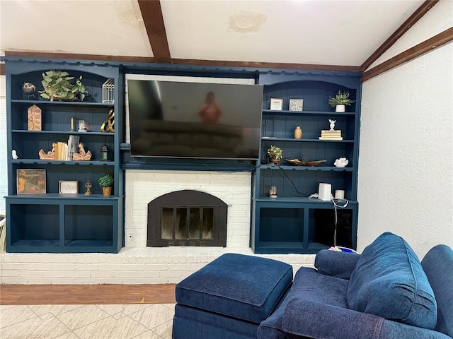 living room featuring vaulted ceiling, built in features, and a fireplace