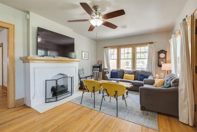 2534 NW 19th St, Oklahoma City, OK 73107 - living room featuring wood finished floors, a ceiling fan, and a fireplace with flush hearth