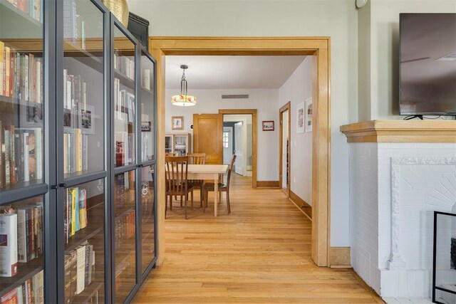 2534 NW 19th St, Oklahoma City, OK 73107 - dining room with light wood-type flooring, baseboards, and a fireplace
