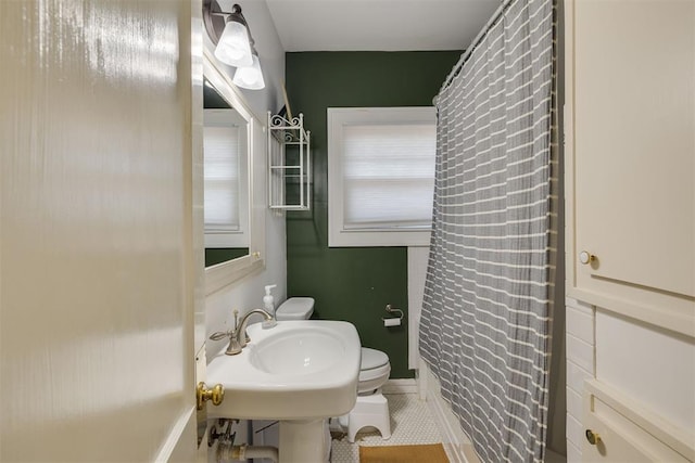 2534 NW 19th St, Oklahoma City, OK 73107 - full bathroom featuring toilet, a sink, baseboards, curtained shower, and tile patterned flooring
