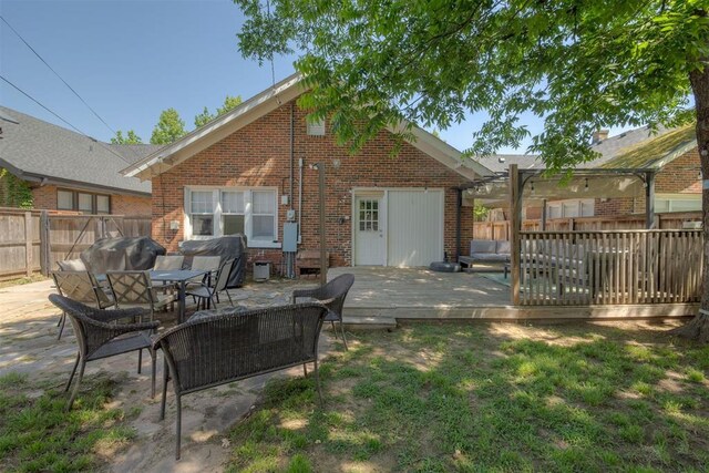2534 NW 19th St, Oklahoma City, OK 73107 - rear view of property featuring brick siding, a fenced backyard, a wooden deck, a patio, and outdoor dining space