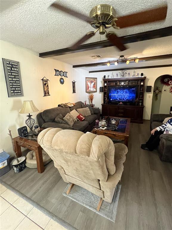 4125 Overland Dr, Del City, OK 73115 - living area featuring a textured ceiling, ceiling fan, wood finished floors, and beamed ceiling