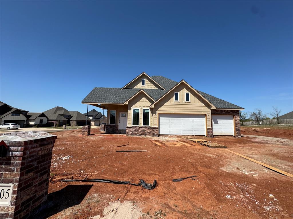 11705 NW 106th St, Yukon, OK 73099 - craftsman inspired home featuring an attached garage, stone siding, a shingled roof, and driveway