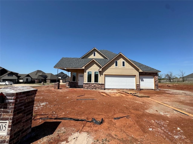 11705 NW 106th St, Yukon, OK 73099 - craftsman inspired home featuring an attached garage, stone siding, a shingled roof, and driveway