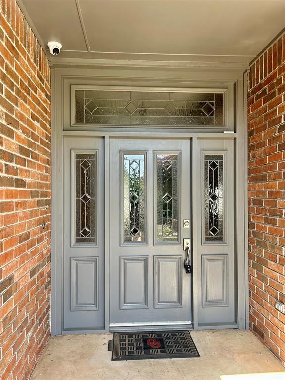 9817 Horseshoe Rd, Oklahoma City, OK 73162 - property entrance with brick siding and a security system