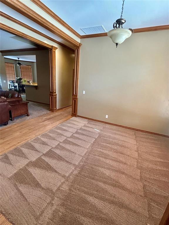 9817 Horseshoe Rd, Oklahoma City, OK 73162 - empty room with ornamental molding, light wood-style flooring, baseboards, and light carpet