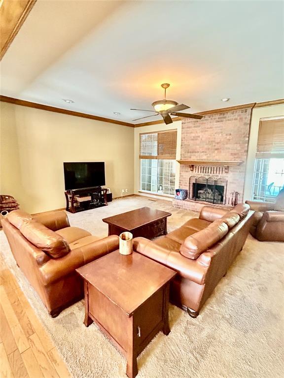 9817 Horseshoe Rd, Oklahoma City, OK 73162 - living area featuring ornamental molding, a brick fireplace, ceiling fan, and wood finished floors