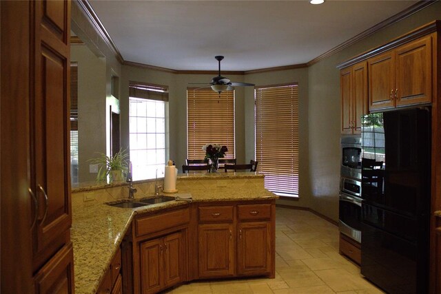 9817 Horseshoe Rd, Oklahoma City, OK 73162 - kitchen featuring stainless steel appliances, a sink, ceiling fan, a peninsula, and brown cabinetry