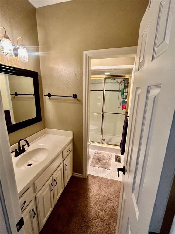 9817 Horseshoe Rd, Oklahoma City, OK 73162 - bathroom featuring a stall shower, vanity, and tile patterned floors