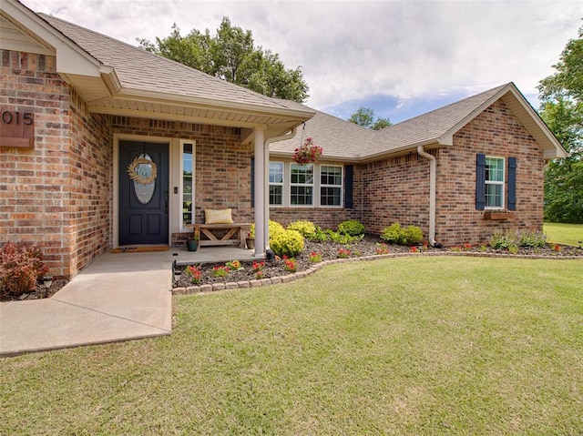 1015 N 3rd Ave, Stroud, OK 74079 - property entrance featuring brick siding, a yard, roof with shingles, and covered porch