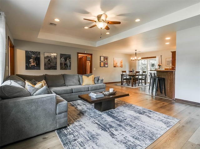 1015 N 3rd Ave, Stroud, OK 74079 - living room featuring ceiling fan, a chandelier, wood finished floors, a tray ceiling, and recessed lighting