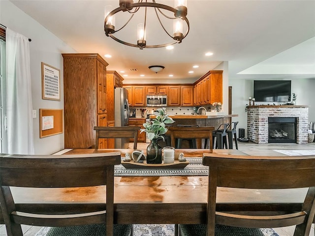 1015 N 3rd Ave, Stroud, OK 74079 - dining space featuring a fireplace, a chandelier, and recessed lighting