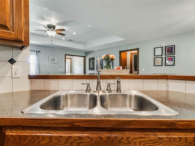1015 N 3rd Ave, Stroud, OK 74079 - kitchen with a sink, ceiling fan, recessed lighting, dark countertops, and a tray ceiling