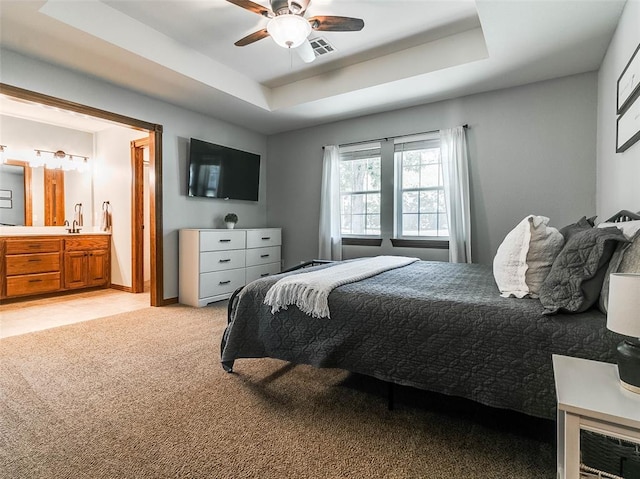 1015 N 3rd Ave, Stroud, OK 74079 - bedroom with a raised ceiling, light colored carpet, ensuite bath, and a ceiling fan