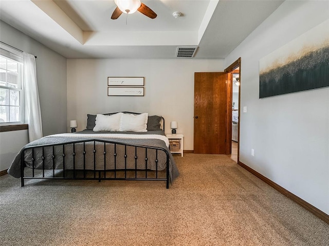 1015 N 3rd Ave, Stroud, OK 74079 - carpeted bedroom with a tray ceiling, baseboards, and a ceiling fan