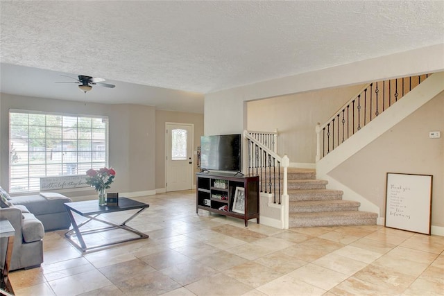 913 NE Dove Ln, Lawton, OK 73507 - living room with a textured ceiling, a ceiling fan, stairway, and baseboards