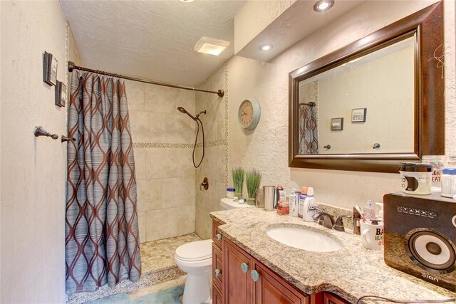 913 NE Dove Ln, Lawton, OK 73507 - full bath with a tile shower, toilet, vanity, a textured ceiling, and a textured wall