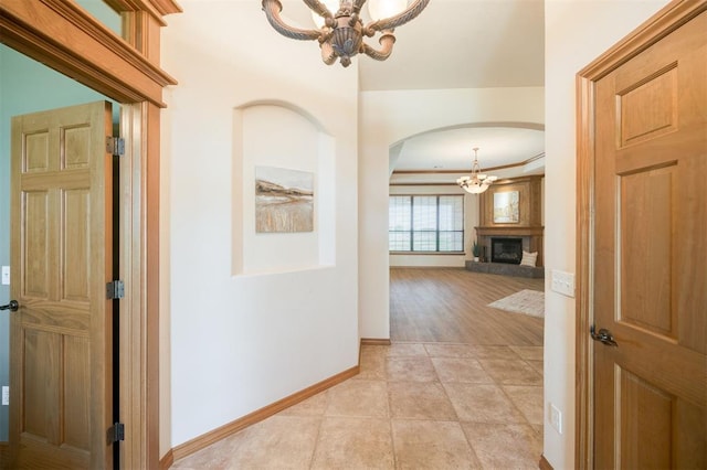 10681 NW 107th St, Yukon, OK 73099 - corridor featuring arched walkways, a chandelier, baseboards, and crown molding