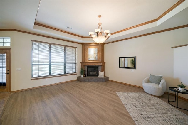 10681 NW 107th St, Yukon, OK 73099 - unfurnished living room with a raised ceiling, a chandelier, ornamental molding, light wood finished floors, and baseboards