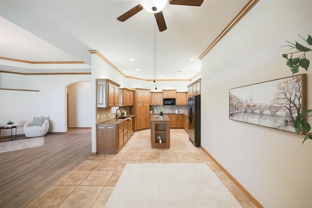 10681 NW 107th St, Yukon, OK 73099 - kitchen featuring black appliances, arched walkways, ornamental molding, a sink, and ceiling fan