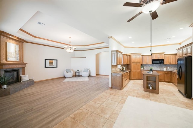 10681 NW 107th St, Yukon, OK 73099 - kitchen featuring black appliances, open floor plan, a sink, crown molding, and arched walkways