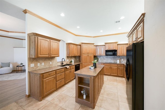 10681 NW 107th St, Yukon, OK 73099 - kitchen featuring black appliances, a sink, a kitchen island, tasteful backsplash, and crown molding