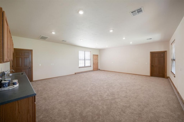 10681 NW 107th St, Yukon, OK 73099 - unfurnished living room featuring a sink, light colored carpet, recessed lighting, and baseboards